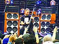 The bassist for grunge band Pearl Jam, Jeff Ament, plays upright bass in front of large, tall bass speaker cabinets. Two cabinets, each with six ten-inch speakers, and two cabinets with four ten-inch speakers, are shown.