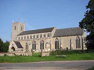 A stone church seen from the south, showing a tower with pinnacles, a nave with clerestory, south aisle, south porch, and a chancel