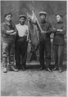 Four unidentified young Indian men with large salmon. - NARA - 297544
