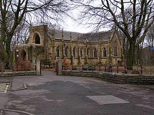 A Gothic-style church seen from an angle with a transept protruding on the right and the porch formed from the truncated tower to the left