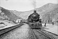 Somewhere in Iran. An American engine transporting allied aid for Russia, stopping at a station rimmed by mountains