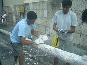 Two men preparing greasy pole for La Tomatina festival