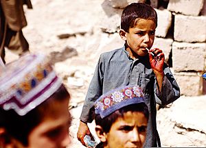 An Afghan child eats a piece of candy received as a gift during a celebration of the Islamic religious holiday of Eid al-Fitr in the Garmsir district of Helmand province, Afghanistan, Aug 110831-M-ED643-011