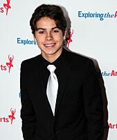 Jake T. Austin smiling in a black shirt.
