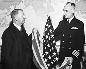 U.S. Secretary of the Navy Frank Knox receives the first U.S. flag had been raised over Kwajalein, 29 February 1944 (80-G-44879)