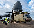 A CH-47F Chinook helicopter is unloaded from a C-5M Super Galaxy
