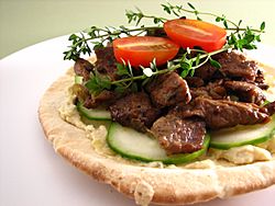 Pita topped with artichoke hummus and lamb