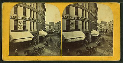 View of unidentified street with commercial buildings, trolley tracks, and buggies, from Robert N. Dennis collection of stereoscopic views