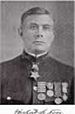 Head of a white man wearing military uniform with many metals adorning it.