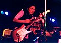 Kim Deal playing guitar with The Amps