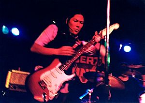 Kim Deal playing guitar with The Amps
