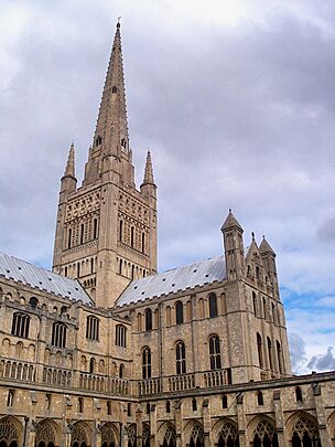 A sturdy tower with Norman details supports a delicate spire framed by four pinnacles.