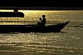 Silhouette of a tourist reading on a boat in Prek Kampi