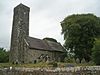 A simple church seen from the southeast with a tall slender tower on the left, then the nave and a chancel with a slightly higher roof line