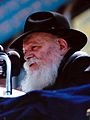 Chest high portrait of Rabbi Menachem Mendel Schneerson wearing a black hat
