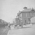 Railroad station showing a man pushing a large cart of boxes, Spokane, ca 1900 (WASTATE 1748)