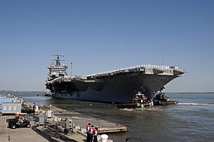 US Navy 060502-N-5681S-040 Tugboats assist the nuclear-powered aircraft carrier USS Enterprise (CVN 65) as it departs Naval Station Norfolk for scheduled deployment in support of the global war on terrorism