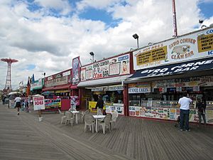 Shops along the boardwalk, with the Parachute Jump, a tall red truss structure, in the background