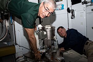 Astronauts Mark Vande Hei and Shane Kimbrough work on a new toilet