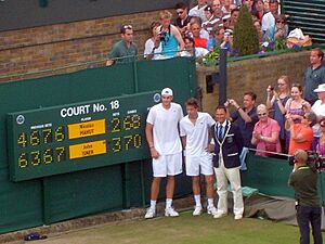 Isner-Mahut-Lahyani next to scoreboard
