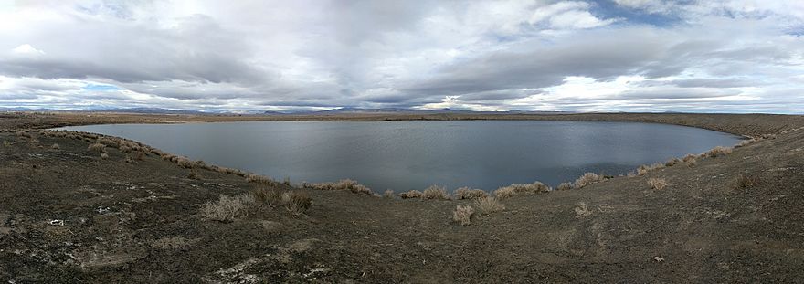 panorama of Big Soda Lake on a cloudy day showing the lake water, steep sides of the crater and surrounding desert landscape