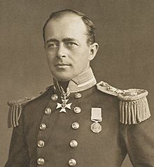 Man with receding hairline, looking left, wearing naval uniform with medals, polished buttons and heavy shoulder decorations