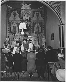Taos County, New Mexico. Father Morgan administers sacrament during Mass at Arroyo Seco. - NARA - 521927