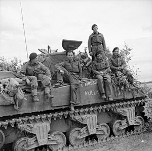 The crew of a Sherman tank named 'Akilla' of 1st Nottinghamshire Yeomanry, 8th Armoured Brigade, after having destroyed five German tanks in a day, Rauray, Normandy, 30 June 1944. B6222