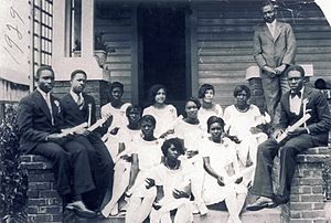 J.N. Crooms posing with the Crooms Academy Class of 1929, on the front steps of his home at 812 South Sanford Ave.