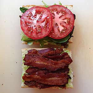 Making a BLT sandwich with avocado and basil mayonnaise