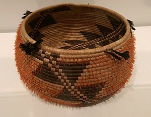 Pomo coiled basket with quail crests and feathers