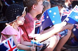 Children wave Australian flags during an Anzac Day parade in Palmerston, Australia, April 25, 2013, as U.S. Marines with the 1st Platoon, Lima Company, 3rd Battalion, 3rd Marine Regiment, Marine Rotational 130425-M-AL626-014