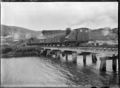 Train crossing a railway bridge over the Tokomairiro River at Waronui, Clutha District. ATLIB 294198
