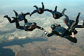US Navy 051214-N-0000L-001 Aviation Structural Mechanic 1st Class Josh Leasure is reenlisted by Lt. Geoff Reeves as other members of the Leap Frogs Navy parachute team look on high above San Diego