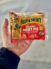Four'n Twenty pie in packaging held by hand