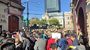 A crowd of protesters in front of soldiers and military vehicles