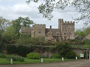 A large house with crenellated towers, set in walled garden.