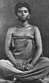 COLLECTIE TROPENMUSEUM Studioportret van een Antankarana vrouw uit het noordoosten van Madagascar in kleermakerszit TMnr 60027431
