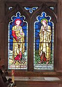  interior of church, showing stained glass window depicting two saints