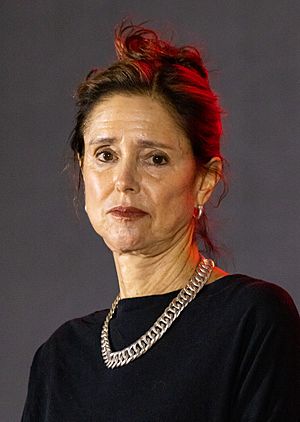 Headshot of Caucasian woman with brown hair wearing black with silver necklace