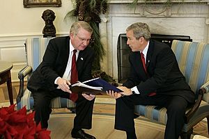 President George W. Bush receives the results of the 2004 Monitoring the Future study from Director John Walters of the Office of National Drug Control Policy