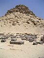 Scattered blocks of black stone on the ground.