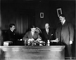 Alfred Shoup, Conrad Freeding, W.W. Shorthill watch Governor Walter E. Clark sign House Bill 2, giving Alaska women the right to vote