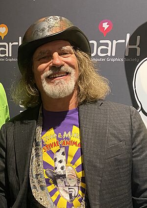 A white male with a grey beard smiles at the viewer