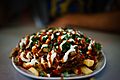 Halal Snack Pack served on ceramic plate, topped with Tablouleh
