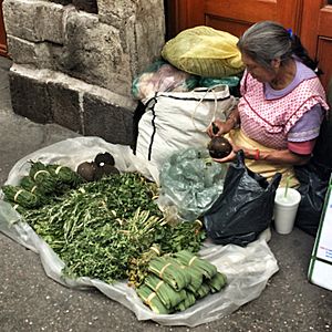 Woman selling herbs from tarp on sidewalk