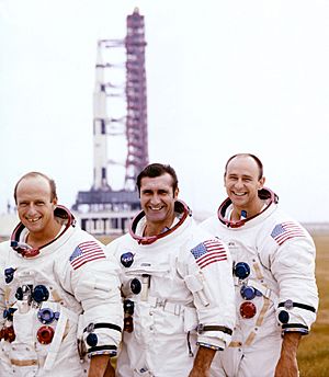 (Left to right) Pete Conrad, Dick Gordon, and Al Bean pose with the Apollo 12 Saturn V