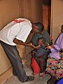 An MSF health worker examines a malnourished child