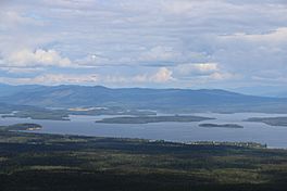 A very large lake with several islands and hills in distance