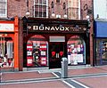 A store called "Bonavox Hearing Aids," on a brick road and next to two other businesses.